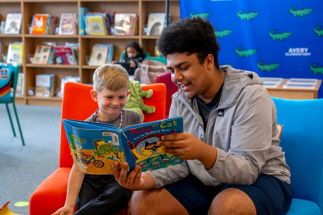 High school student mentoring an elementary reader
